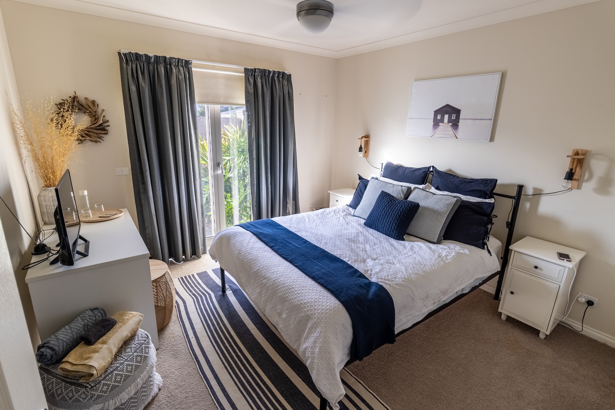 A guest bedroom at Charm Lodge with a king bed made up in navy and white linen