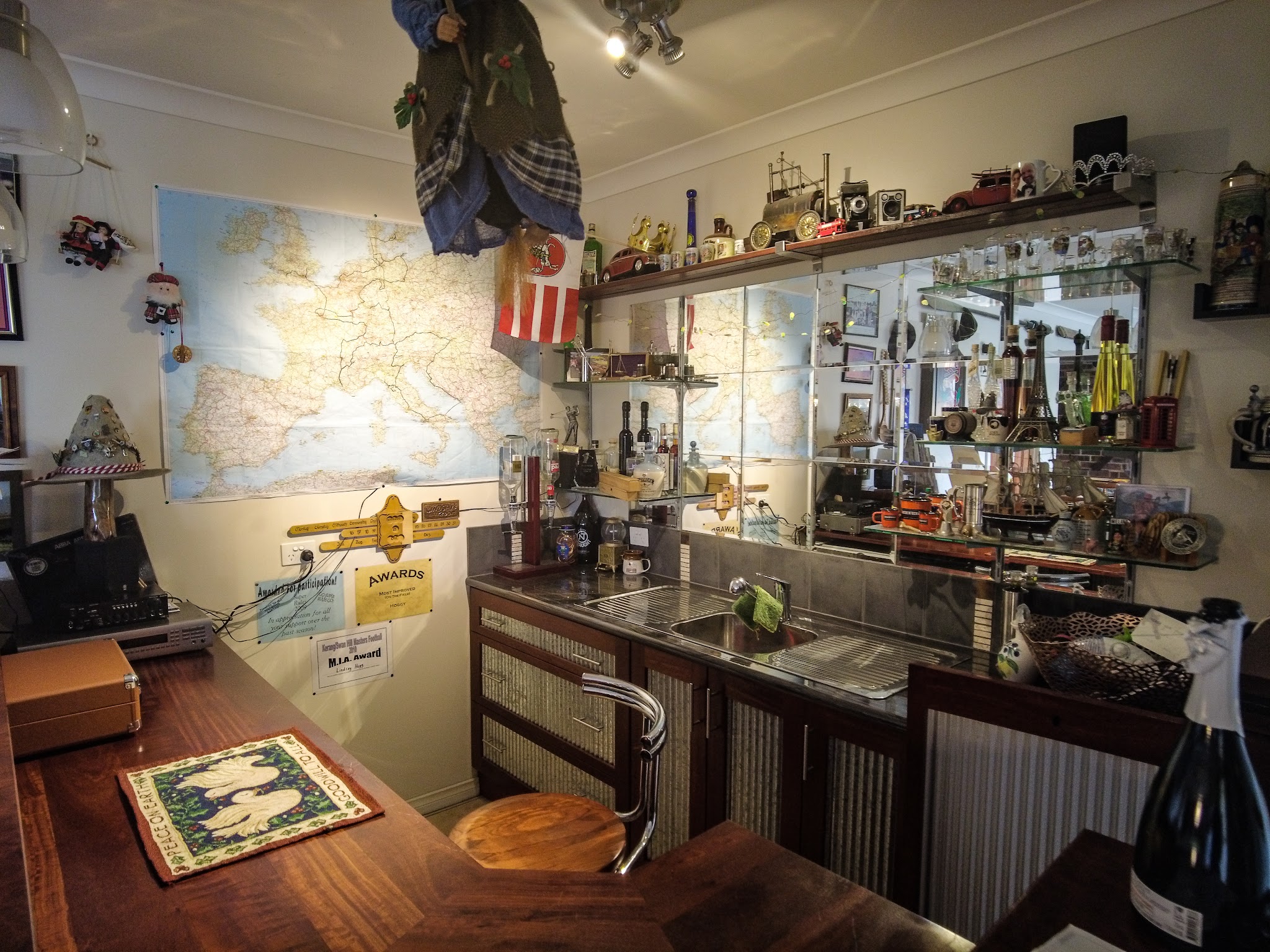 The bar and collection room inside the lodge, with a mirrored back bar, glassware, model cars and a large wall map of Europe